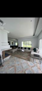 een woonkamer met een bank en een open haard bij Maison d'hôtes les berges du lac in Tunis