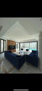 een woonkamer met een blauwe bank en een tafel bij Maison d'hôtes les berges du lac in Tunis