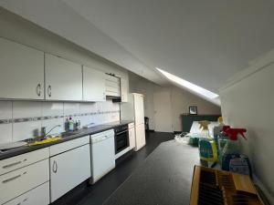 ハインスベルクにあるFerienwohnung-Emiliaの白いキャビネットと冷蔵庫のあるキッチン