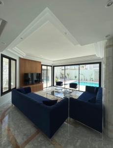 een woonkamer met twee blauwe banken en een glazen tafel bij Maison d'hôtes les berges du lac in Tunis