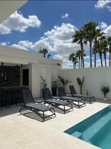 een groep stoelen naast een zwembad bij Maison d'hôtes les berges du lac in Tunis