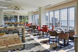 a restaurant with tables and chairs and large windows at Icon Brickell Residences by Skyline Rentals in Miami