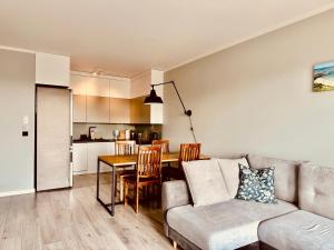 a living room with a couch and a table at Baltic Inspiration - Guest Favorite, Excellent Location, 2 King Bedrooms, Jacuzzi Bath, Parking in Gdańsk