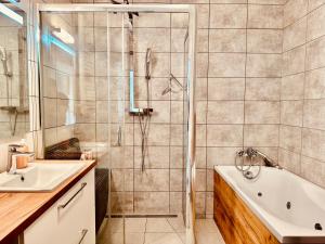 a bathroom with a shower and a tub and a sink at Baltic Inspiration - Guest Favorite, Excellent Location, 2 King Bedrooms, Jacuzzi Bath, Parking in Gdańsk +10 photos