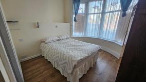 ein Schlafzimmer mit einem Bett und einem großen Fenster in der Unterkunft Park Road Guest House - Room To Rent On Park Road in Blackpool FY1 4ET in Blackpool