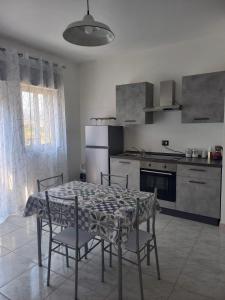 a kitchen with a table and some chairs and a table and a kitchen at Giumati in Mascali