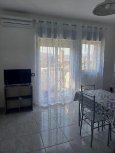 a bedroom with a bed and a television and a chair at Giumati in Mascali