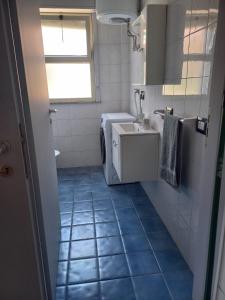 a bathroom with a blue tiled floor and a sink at Giumati in Mascali