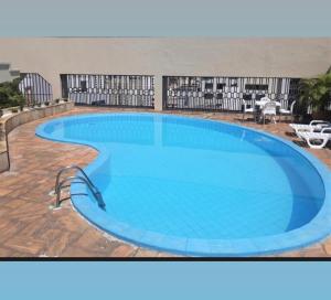 a large swimming pool in a hotel at La Residence Elegante Flat Goiânia - Liah in Goiânia