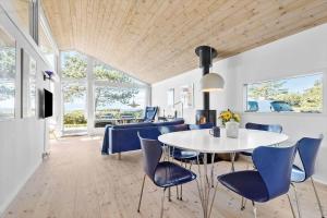 克内贝尔8238-Knebel-Begtrupvig-Strandvej-57的一间有白色桌子和蓝色椅子的餐厅