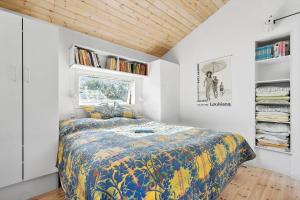 克内贝尔8238-Knebel-Begtrupvig-Strandvej-57的卧室里有一张床，床上铺着色彩鲜艳的被子