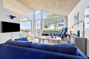 克内贝尔8238-Knebel-Begtrupvig-Strandvej-57的客厅里有一张蓝色的沙发和一张桌子