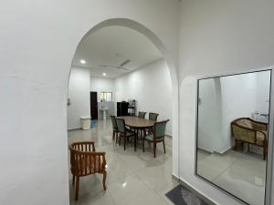 a dining room with an archway and a table and chairs at Homestay Taman Laksamana, Muar in Muar