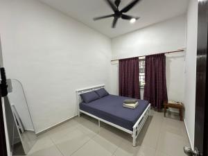 a bed in a room with a ceiling fan at Homestay Taman Laksamana, Muar in Muar