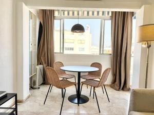 un tavolo e sedie in un soggiorno con finestra di The Suit III Marbella Center - EaW Homes a Marbella