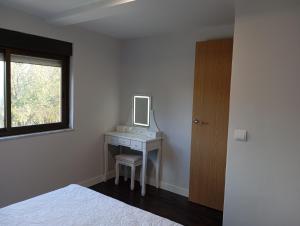 a bedroom with a desk with a mirror and a bed at La Casa de Pepe in Muros de Nalón +5 photos