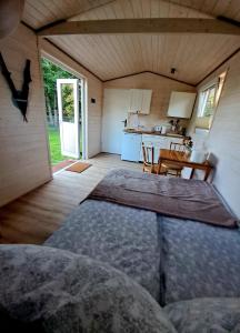 a room with a bed and a kitchen with a table at Mały Domek in Pollnow