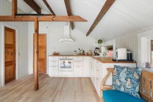 1619-Gilleleje-Ulvehojen-5 في جيليليه: مطبخ فيه دواليب بيضاء وكرسي ازرق +14 صورة