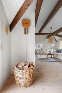 1619-Gilleleje-Ulvehojen-5 في جيليليه: غرفة معيشة مع سلة ويكر على الأرض