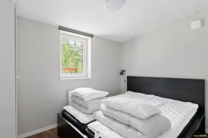 Un dormitorio con una cama con sábanas blancas y una ventana. en First Camp Skara Sommarland, en Axvall