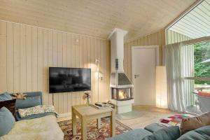 a living room with a couch and a fireplace at 1481-N-Tisvildeleje-Bakkefrydvej-1 in Tisvildeleje