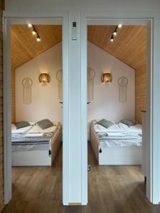two beds in a room with two mirrors at Domki Przy Brzegu Chłapowo in Władysławowo