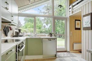a kitchen with a sink and a large window at 1481-N-Tisvildeleje-Bakkefrydvej-1 in Tisvildeleje +12 photos
