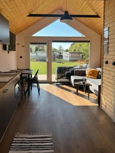 a kitchen and living room with a ceiling fan at Domki Przy Brzegu Chłapowo in Władysławowo +49 photos