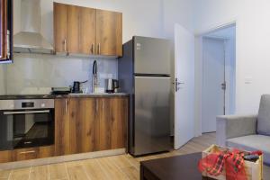 a kitchen with a stainless steel refrigerator and wooden cabinets at Limeni koilakos Suite in Limeni