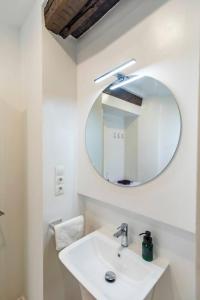 カディスにあるApartamentos La Cruz Verdeの白い洗面台と鏡のあるバスルーム