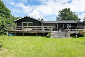 a black house with a porch and a yard at 1586-Melby-Anna-Borgsvej-19 in Melby