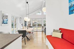 a kitchen and dining room with a red couch and a table at 1503-Gilleleje-Vibehusvej-9 in Gilleleje