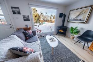 a living room with a couch and a fireplace at Spa & River view - Le Jardin in Montmagny