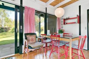 una sala da pranzo con un tavolo e sedie rosse di 1007-N-Hundested-Humlehaven-5 a Hundested Altre 8 foto