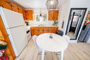 a kitchen with a white table and a white refrigerator at Spa & River view - Le Jardin in Montmagny