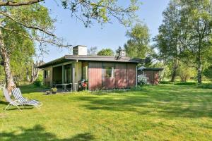 una casa con un cortile con una sedia davanti di 1007-N-Hundested-Humlehaven-5 a Hundested