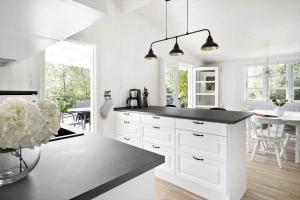 a kitchen with white cabinets and a black counter top at 872-N-Melby-Reinsholmvej-15 in Melby