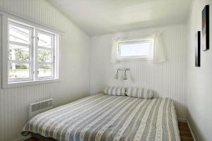 a bedroom with a bed and two windows at 872-N-Melby-Reinsholmvej-15 in Melby