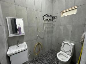 a bathroom with a shower and a toilet and a sink at Homestay Taman Laksamana, Muar in Muar +2 photos