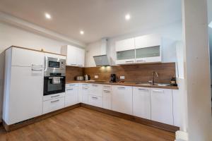 a kitchen with white appliances and wooden floors at Ferienwohnung im Rentmeisterhaus an der Burg in Beverungen