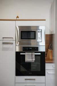 a stainless steel oven with a microwave in a kitchen at Ferienwohnung im Rentmeisterhaus an der Burg in Beverungen +14 photos