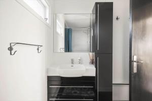 een badkamer met een wastafel en een spiegel bij 1639-Frederiksvaerk-Genvejen-10 in Frederiksværk +25 foto's