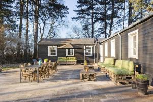 een huis met een terras met een tafel en stoelen bij 1639-Frederiksvaerk-Genvejen-10 in Frederiksværk