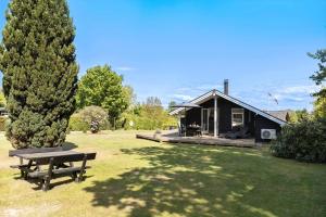 a cabin in a park with a picnic table in the grass at 1630-Frederiksvaerk-Munkebakken-2 in Frederiksværk