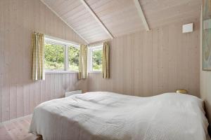 a bedroom with a white bed and two windows at 1650-Asserbo-Fyrrevangen-17 in Asserbo