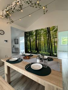 a dining room with a table with plates and glasses at Waldzauber - Moderne Ferienwohnung im Grünen in Elpenrod
