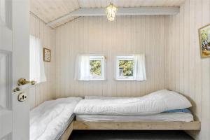 a bed in a room with two windows at 617-N-Melby-Bakkely-8-B in Melby