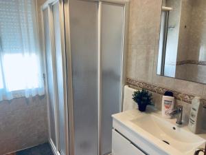 a bathroom with a shower and a sink and a mirror at Casa Hay que Vivir el Momento in Setenil