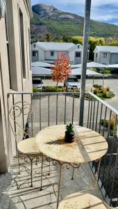 a table and chairs on a balcony with a view of a street at The Madge Self Catering in Paarl +13 photos