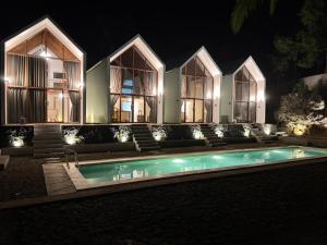a house with a swimming pool at night at Villa Suaka by Sackstone in Watukarung